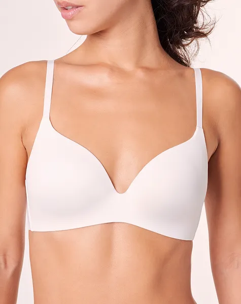 Grande plano do peito de uma mulher com um sutiã branco liso.