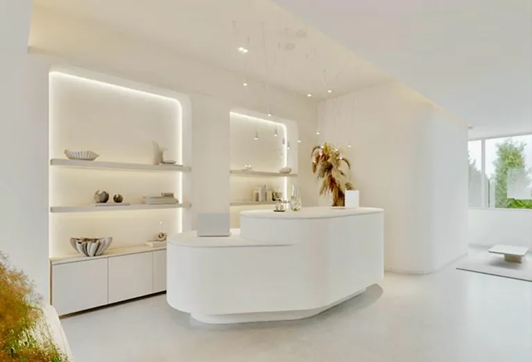 Receção da clínica com um balcão branco de linhas curvas e orgânicas, prateleiras iluminadas e um ambiente clean e minimalista.