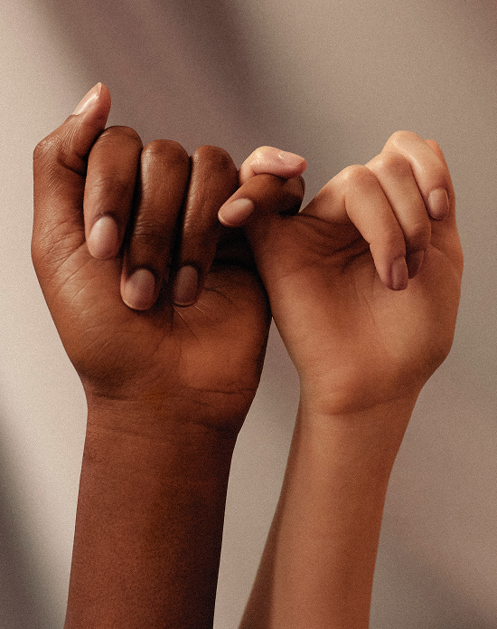 Duas mãos, de pessoas distintas, entrelaçadas